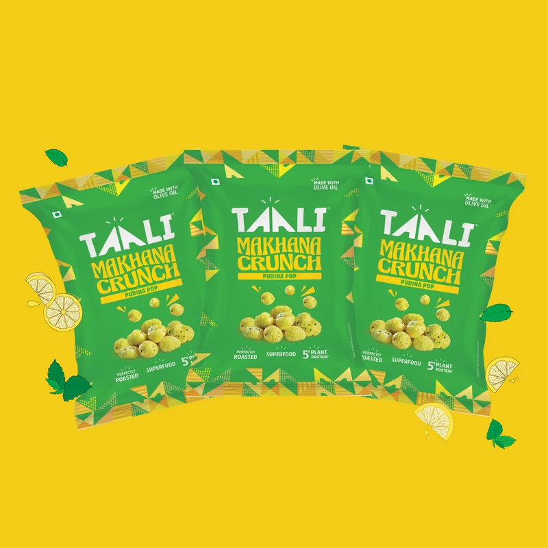 Taali Roasted Makhana Crunch in Pudina Pop, retail packs fanned out on a flat colour tile