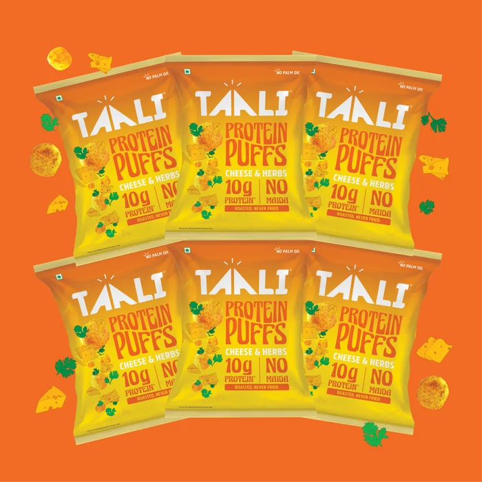 Taali Protein Puffs Cheese and Herbs 60 g packs fanned out on a flat colour tile